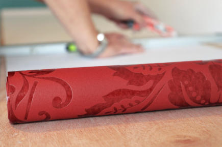 Symbolbild Tapezierarbeiten: Tapetenrolle auf einem Tapeziertisch